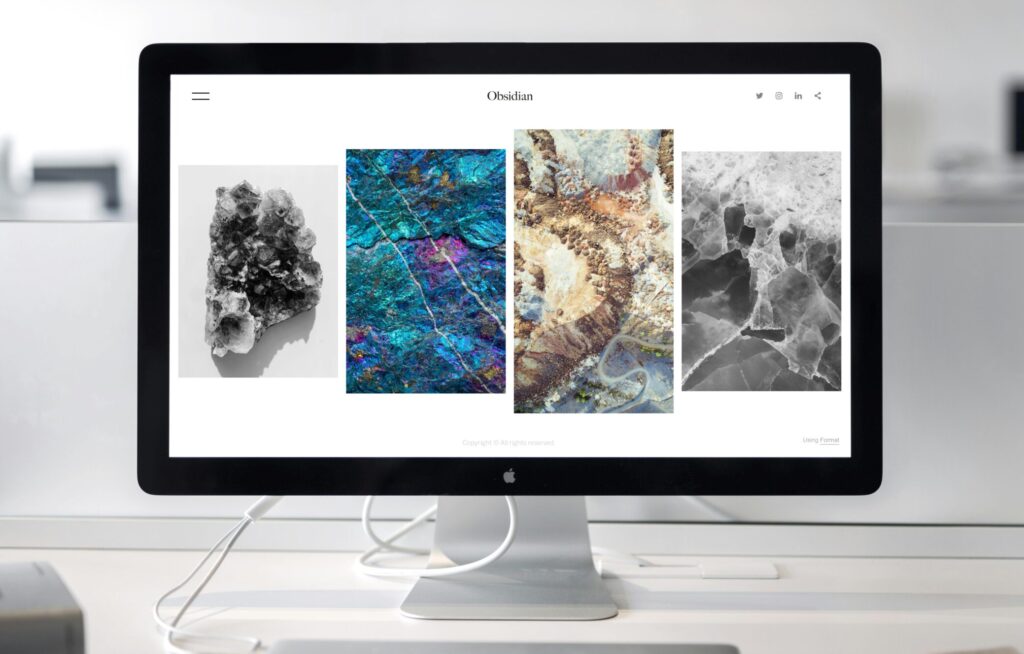 A contemporary office desk setup featuring a sleek computer monitor displaying abstract artwork.